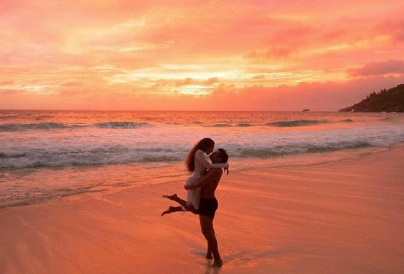 Casal em praia com pôr do sol Casal em praia com pôr do sol